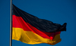 The German flag waves on the top of Reichstag building, house of the German Government in...