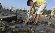 A young volunteer removes garbage from a beach in Mumbai 