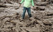 A man walked among the stones of cold lava eruption of Mount Sinabung has been eroding for...