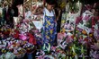 A flower vendor ties her apron next to flower bouquets for sale a day before Valentine's D...