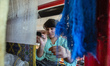 Woman weaves the silk carpet with Afghan royal pattern and 80 knots per centimetre at the...