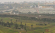 A general view of the border fence deviating between an Islamic Cemetery and a Golf Course...
