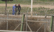 A group of women walk on the Mrocco side of the border fence at the Morocco–Spain border i...