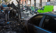 A couple look at a burned recycle containers in a street in the center of Madrid on Novemb...