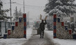 A security personnel carries furniture amid heavy snowfall in Baramulla, India, on 2 Janua...