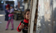 A Palestinian girl looks through the gate of her family's house in Beit Lahia in the north...