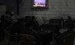 People watch Abu Obaida, the spokesman for the Ezzedine Al-Qassam Brigades, the armed wing...