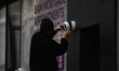 A technician is instaling a CCTV - security camera outside a Dublin City Center branch of...