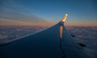 Wing view from the window of an airliner during the magic hour after the sunset. The aircr...