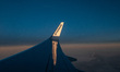 Wing view from the window of an airliner during the magic hour after the sunset. The aircr...