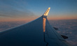 Wing view from the window of an airliner during the magic hour after the sunset. The aircr...