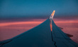 Wing view from the window of an airliner during the magic hour after the sunset. The aircr...