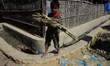 A Rohingya refugee child carries bamboo pieces in the Balukhali refugee camp in Ukhia, Cox...