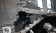 Child looking out the gap of the door of his house destroyed in Shijia neighborhood during...