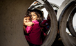 A group of refugee kids are hiding in the drain pipes from the burning sun and using them...