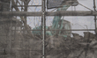 An excavator with debris of buildings behind the construction net in Namie, Fukushima pref...