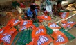 Slum dewllers are hired by Bharatiya Janata Party (BJP) to prepare their party logo flags...