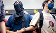 Demonstrators block the passage to the turnstiles of a subway station during a protest aga...