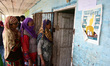 Kashmiri people stand in line to cast the votes outside polling booth in Shadipora area of...