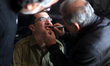 Actor Mahmoud Karira, who plays Gilad Schalit, has makeup applied by an assistant during f...