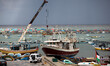 Palestinian Territory - Fishing boats are seen anchored as a huge wave crashes over a sea...
