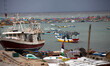 Palestinian Territory - Fishing boats are seen anchored as a huge wave crashes over a sea...