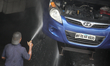A man washes a car at garage in Mumbai, India on 23 June 2019. 
