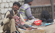 Man holds his sick child as he begs along the roadside in Choglamsar, Ladakh, Jammu and Ka...
