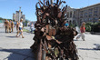 People walk next to the art object 'The Iron Throne of the East', which presented on the I...