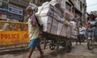 A man pulls stationery filled handcart through Chawri Bazaar in Old Delhi, India, on 20 Ju...