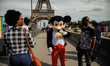 People are seen walking in front the Eiffel Tower is in Paris France on August 06, 2019 