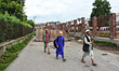People walk past the blocked road leading to Jinab Sahab Soura, Srinagar, Indian controlle...