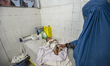 Mother wearing traditional Muslim burka and her child in Central Hospital of Afghan Red Cr...