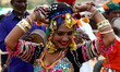 Rajasthani folk artist and Foreign tourist dances during a procession on the evening of Wo...