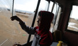 A Palestinian boy pulls glass shards from a broken window at his home near the site of Isr...