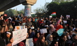 Students and local residents hold placards and raise slogans as they take part in a protes...