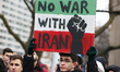 Man holds a sign saying 'No War with Iran' as Canadians held a protest outside the America...