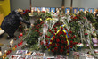A woman lays flowers in memory of the passengers and the crew members of the Ukrainian Boe...