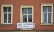 Message 'Is Coming Soon...' on a banner seen on a balcony in Kazimierz area of Krakow.The...