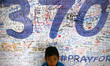 A young child poses for the camera at the "wall of hope" as it enters the ninth day of the...
