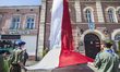 Boys scouts extend  a large polish flag from a balcony in Skierniewice during the celebrat...