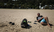 A man poses for pictures as he lies on the sand of the beach of the coastal town of Sidi B...
