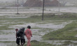 Residents walk along a street to a shelter ahead of the expected landfall of cyclone Ampha...