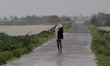 Resident walks along a street to a shelter ahead of the expected landfall of cyclone Ampha...