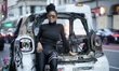 A woman poses in front of a burnt NYPD police car as protestors rally against the death of...