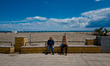 Two elderly gentlemen chatting while sitting on the bench and behind the still empty beach...