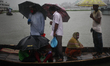People cross the river Buriganga through boat during a heavy rainfall  in Dhaka, Banglades...