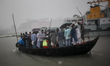 People cross the river Buriganga through boat during a heavy rainfall  in Dhaka, Banglades...