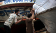 Laborers carry goods to a launch after the government-imposed lockdown at Sadarghat launch...
