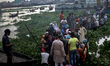 People cross the river Buriganga through boat after a heavy rainfall in Dhaka , Bangladesh...